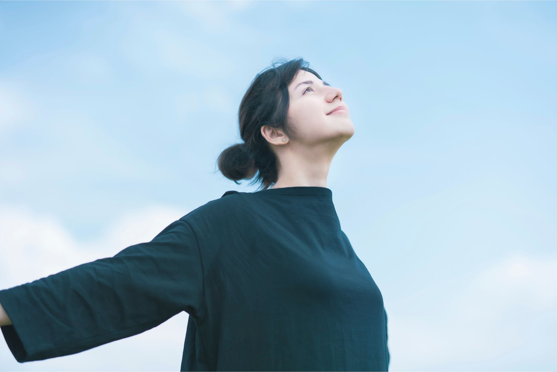 空を見上げる女性の画像